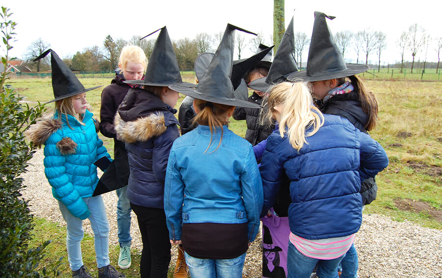 Kinderen tijdens een heksenfeestje met een heksenhoed